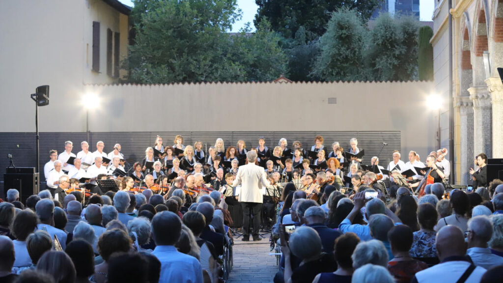 Il Coro e l'Orchestra Sinfonica Amadeus in concerto con il direttore, pubblico seduto in primo piano, immagine allegata al comunicato.